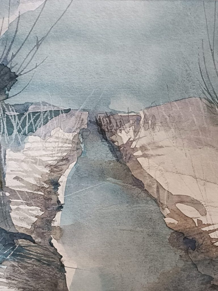 Landschaft mit einem schmalen Wasserweg zwischen hohen Ufern unter bewölktem Himmel.